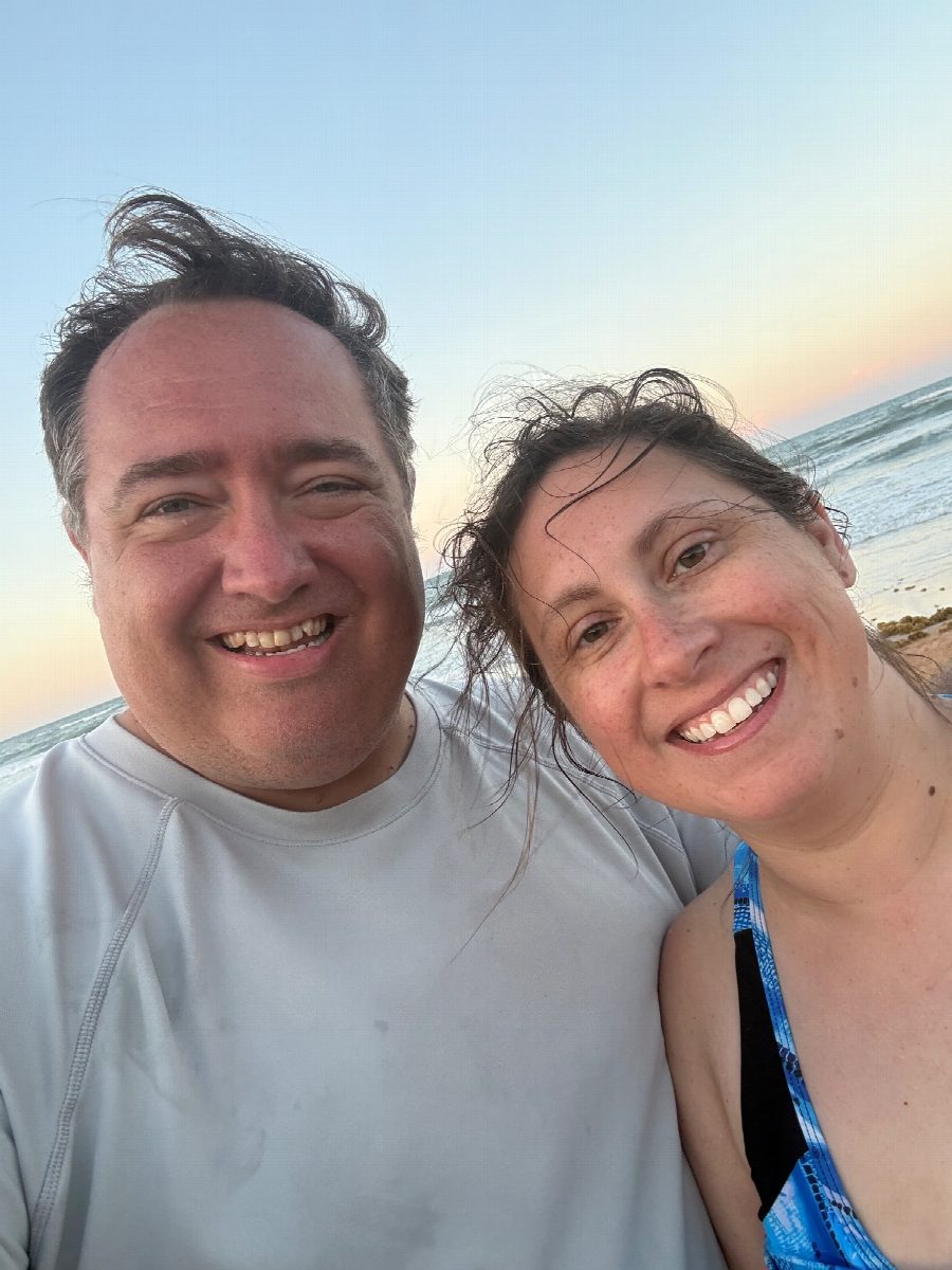 Elisha and R.J. smiling on the beach at sunset