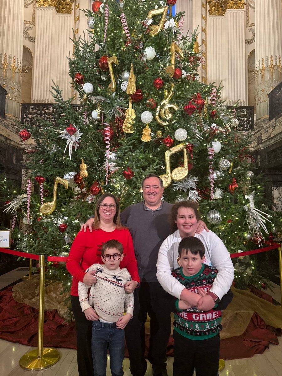 The Nestor family in front of a Christmas tree decorated with gold instruments at Heinz Hall